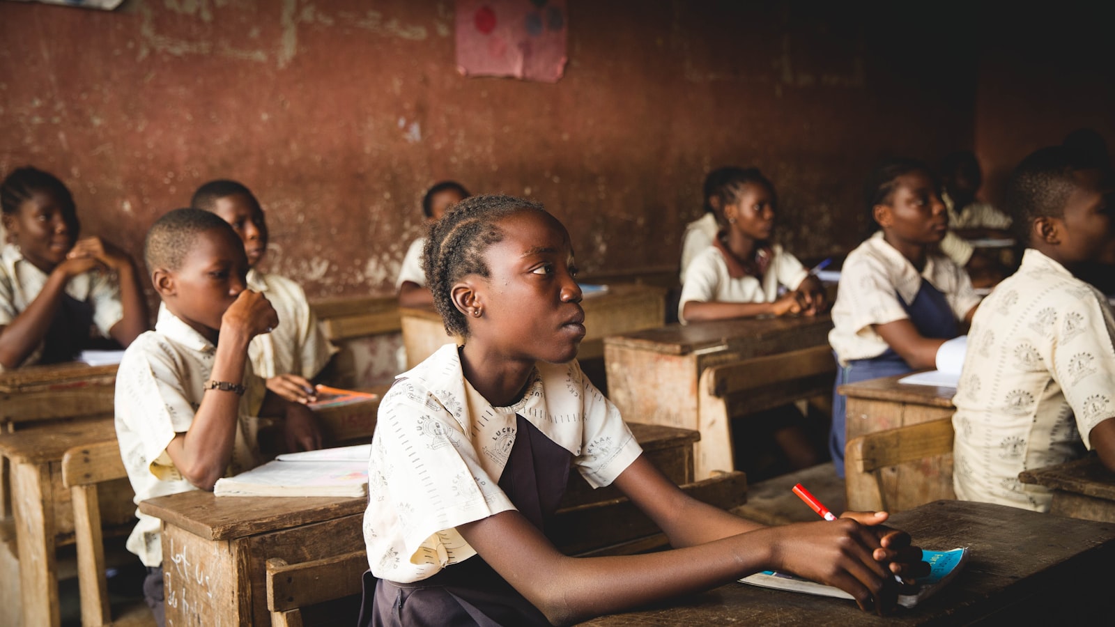 Students seated at wooden desks in a classroom in Lagos, Nigeria.
